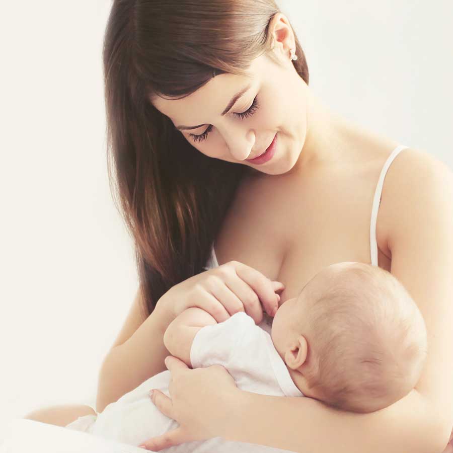 Eine Mutter stillt ihr Baby in einer zärtlichen, liebevollen Athmosphäre.